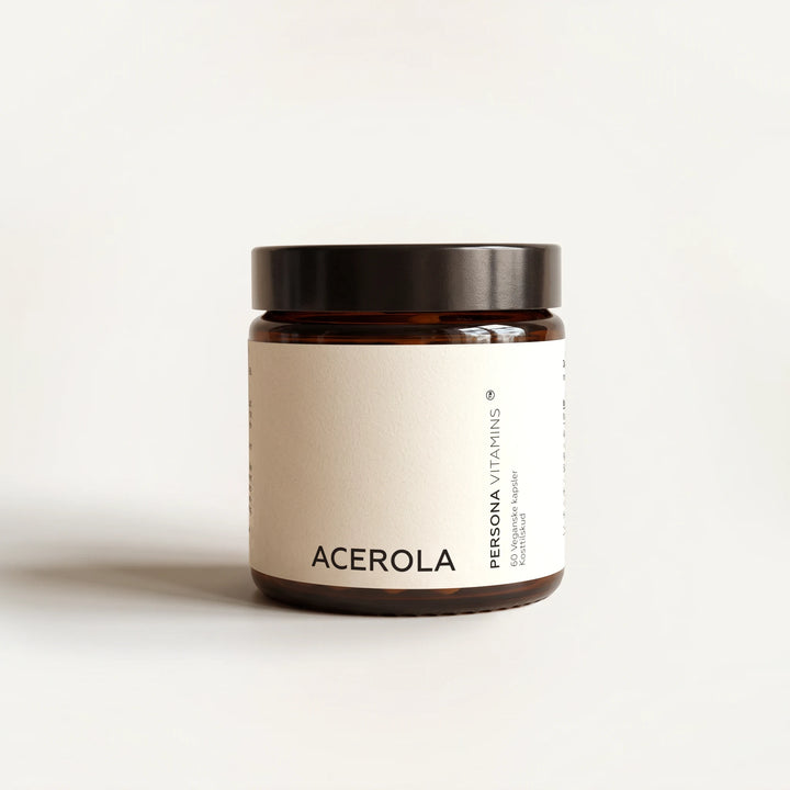 Amber glass jar with a black lid and a Acerola label on a cream background, straight-on view
