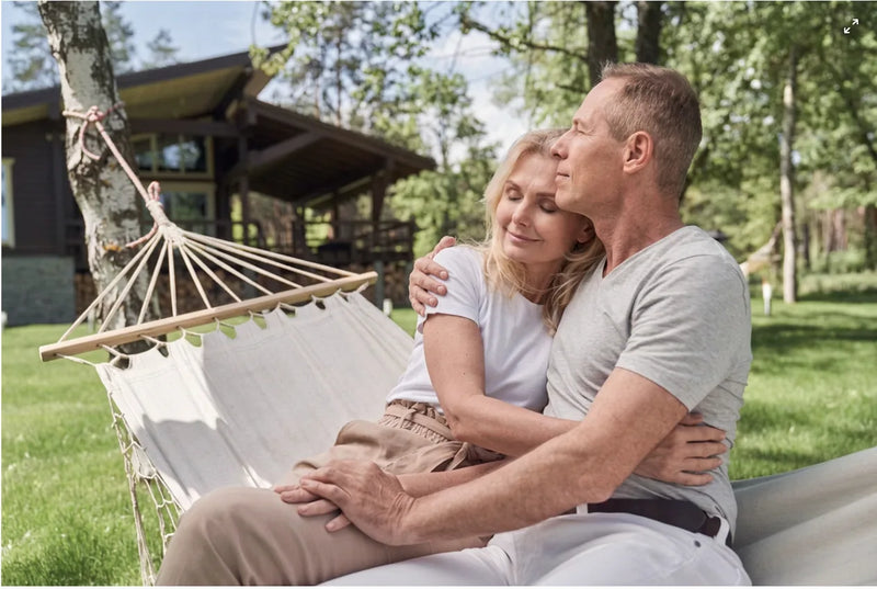 Older couple embracing in a hammock in a garden