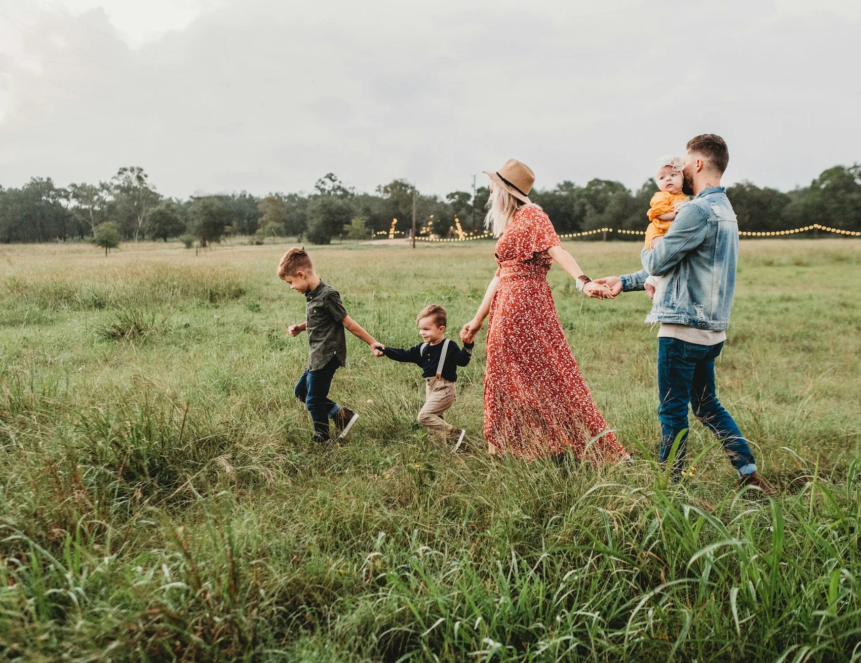 Family walking together in a field holding hands