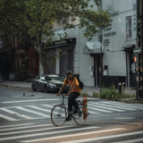 Cyclist crossing a zebra crossing on a city street, photo by Lerone Pieters