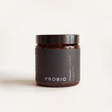 Amber glass jar with a black lid and a dark Probio label on a cream background, straight-on view