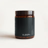 Amber glass jar with a black lid and a Sleep+ label on a cream background